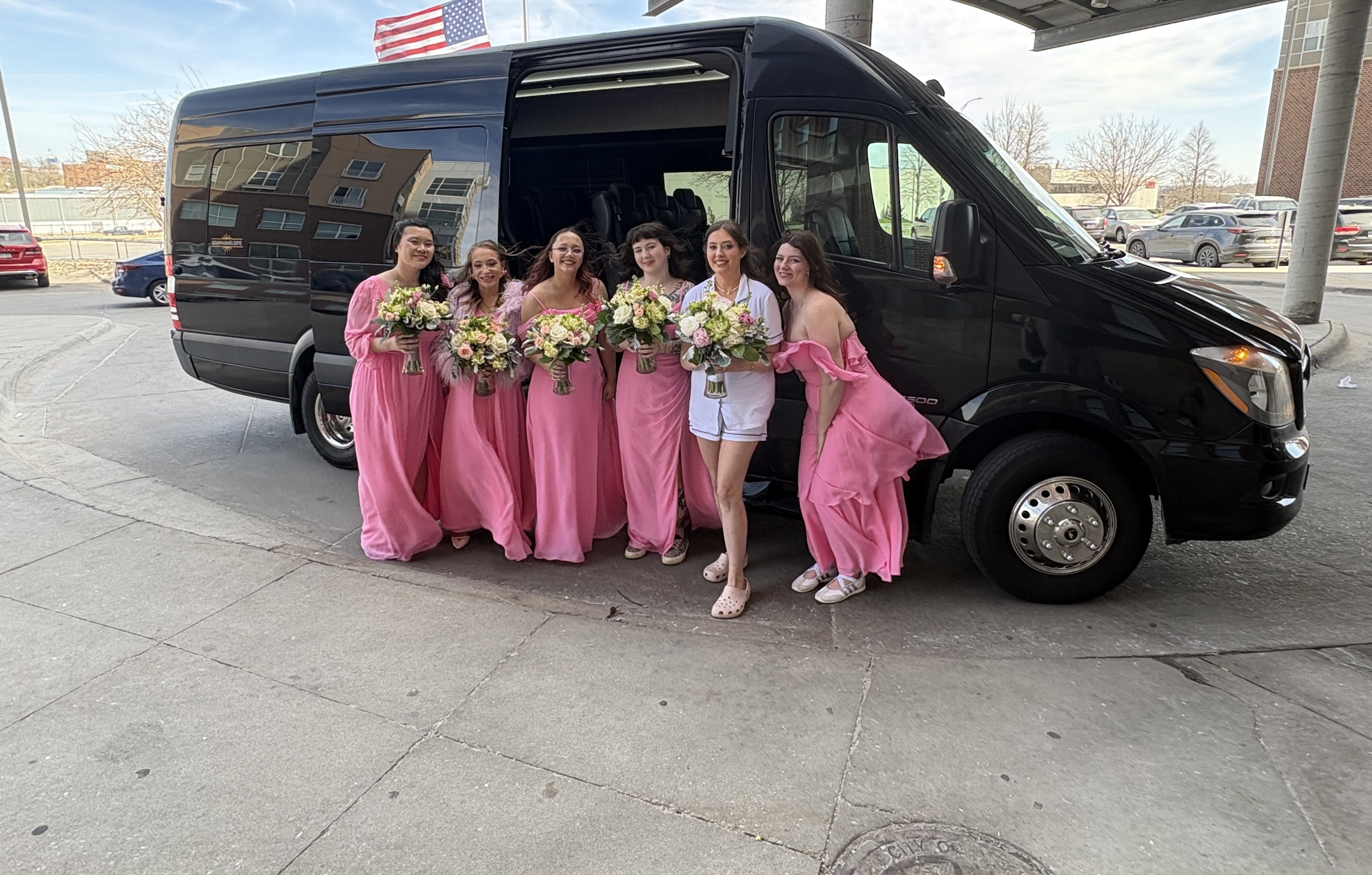Wedding party in pink dresses with bouquets boarding the VET'd Transportation van
